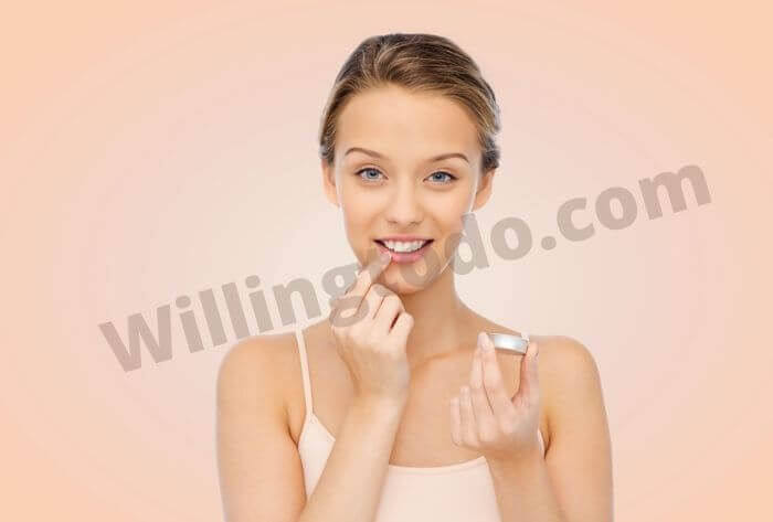 Woman is applying Lip Gloss made with Vaseline to shine her lips
