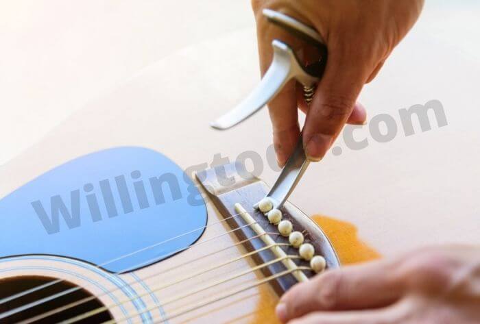 Remove old bridge pins of guitar