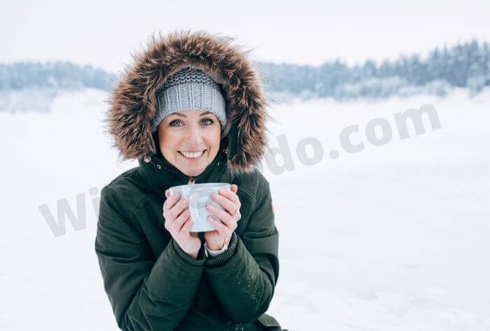 Woman take tea in snow to keep hydrated