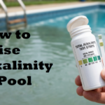 Checking pool water levels with a test strip to determine how to raise alkalinity in pool